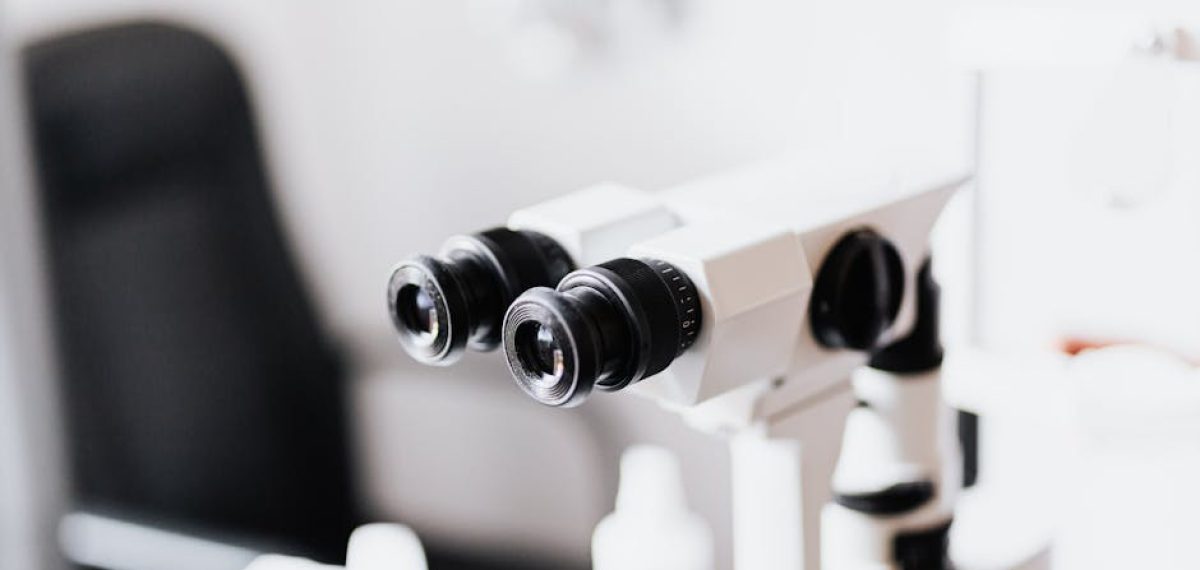Close-up of a professional microscope in a laboratory environment with selective focus.